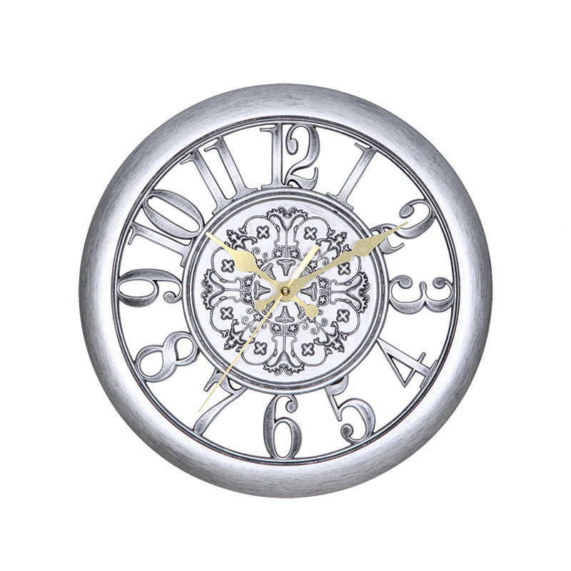 Silver wall clock with decorative face on a white background
