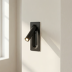 Modern black door handle on a white door with sunlight casting shadows.