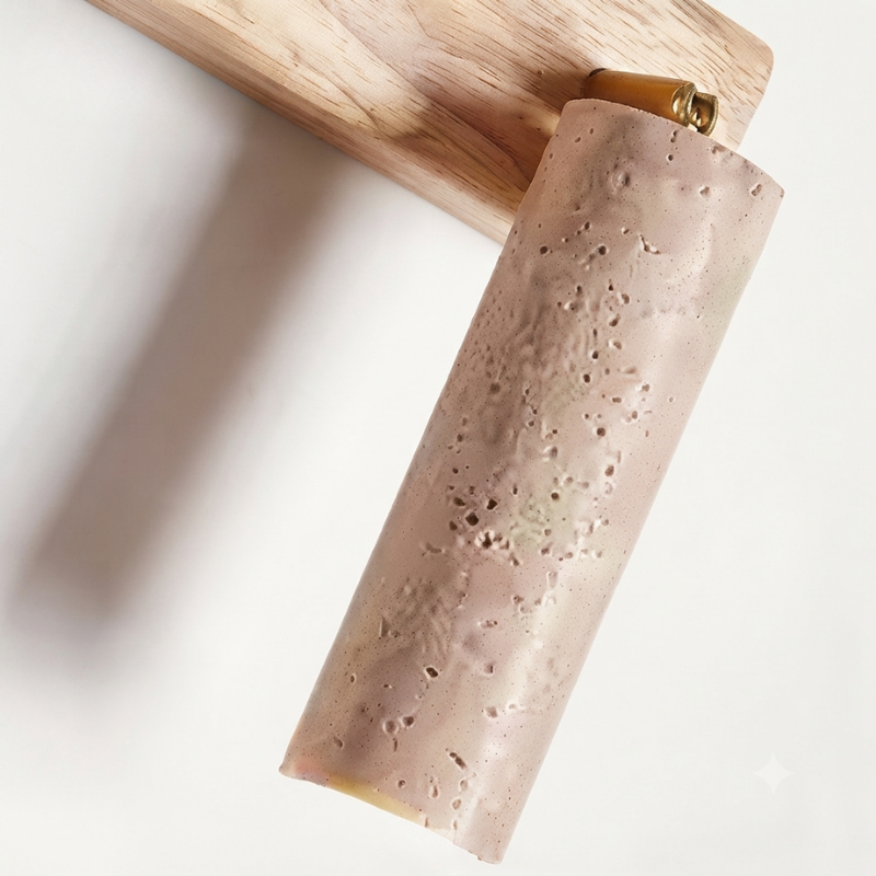 A rolled sheet of pale pinkish-beige textured material, possibly leather, paper, or clay, shown hanging from a wooden block against a white background.