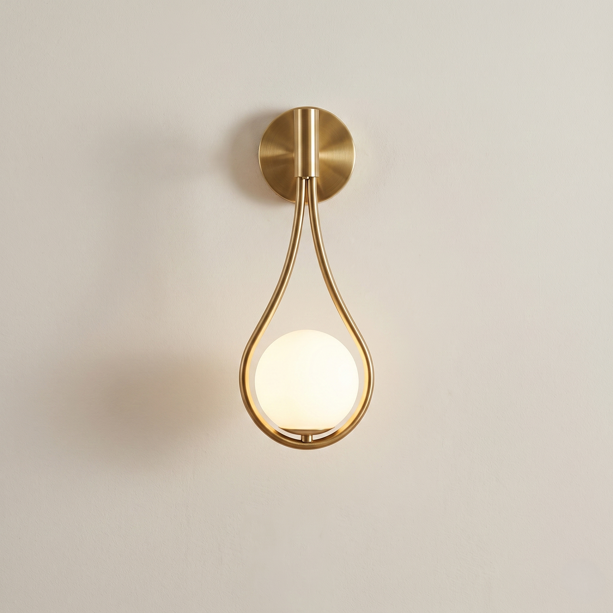 Gold wall sconce with a round light bulb on a beige background