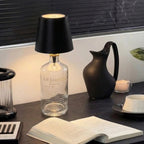 Decorative setup with a lamp, book, and other items on a dark surface.