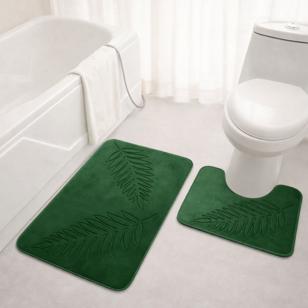 Green bath mat with leaf pattern on a bathroom floor.