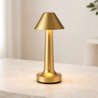 Gold table lamp on a light surface with a neutral background