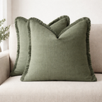 Green pillows with frayed edges on a beige sofa