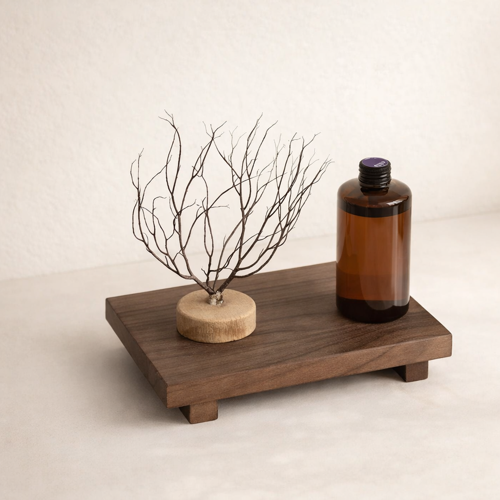 Wooden tray with a bottle and decorative branch on a beige background
