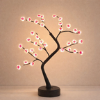 Decorative LED tree with pink blossoms on a beige background