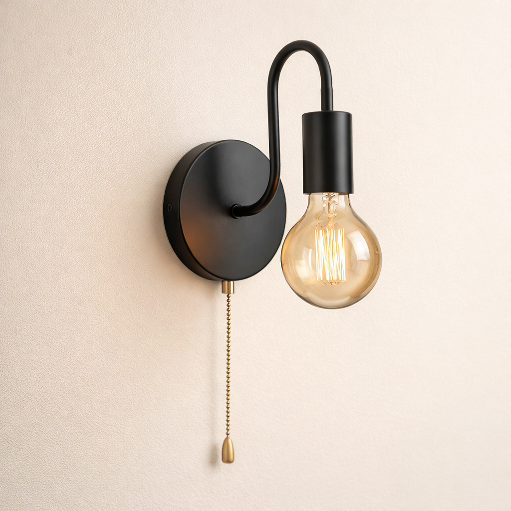 Black wall-mounted light fixture with a pull chain on a beige wall.