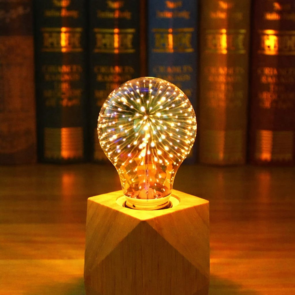 Decorative light bulb on a wooden base with books in the background