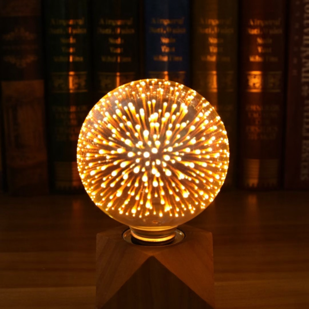 Decorative light bulb with a fiery design on a stand against a bookshelf background