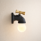 Wall-mounted light fixture with black base and gold accent on a beige wall.