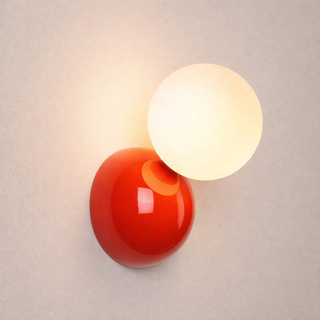Wall-mounted lamp with red and white spherical shades on a neutral background