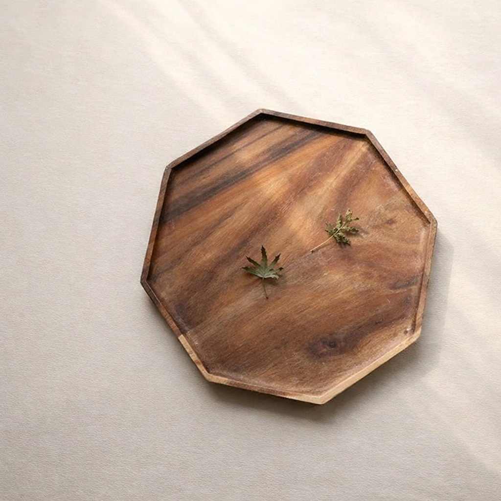Wooden octagonal tray with natural finish on a beige background