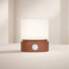 Table lamp with a brown base and white shade on a neutral background