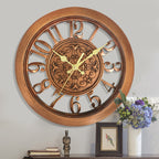 Decorative wall clock with wooden frame and Roman numerals on a gray wall.
