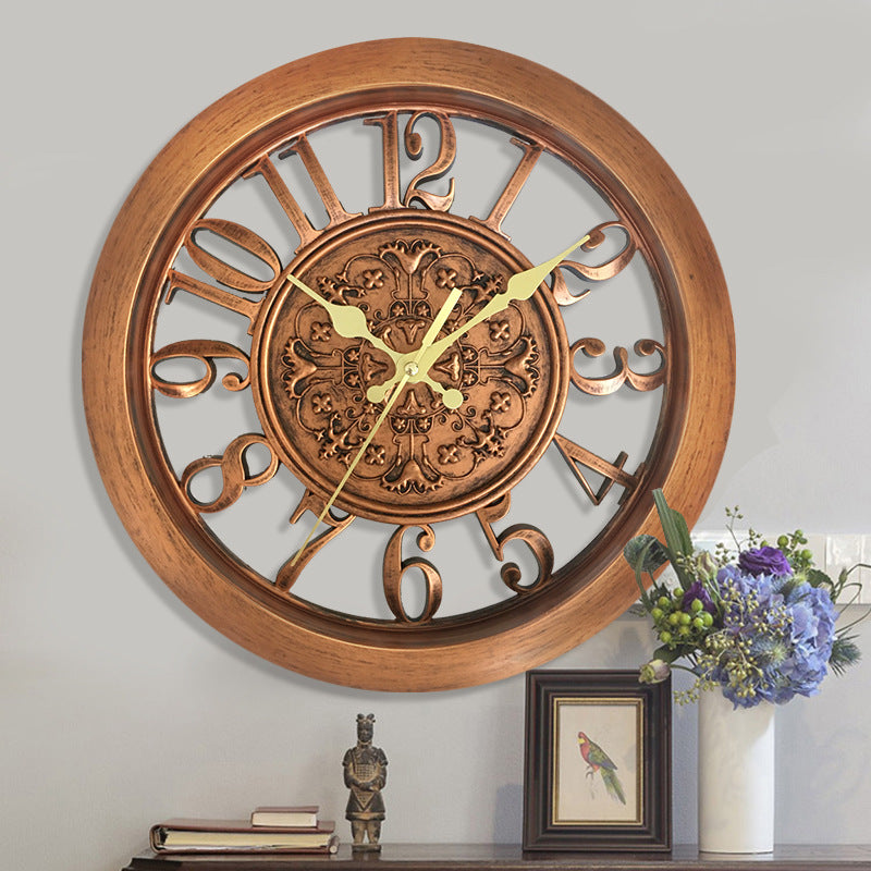 Decorative wall clock with wooden frame and Roman numerals on a gray wall.