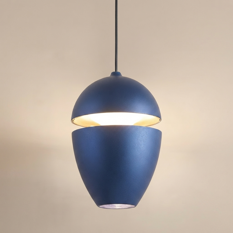 A modern blue pendant light with a split acorn design, suspended by a black cord against a warm beige background.
