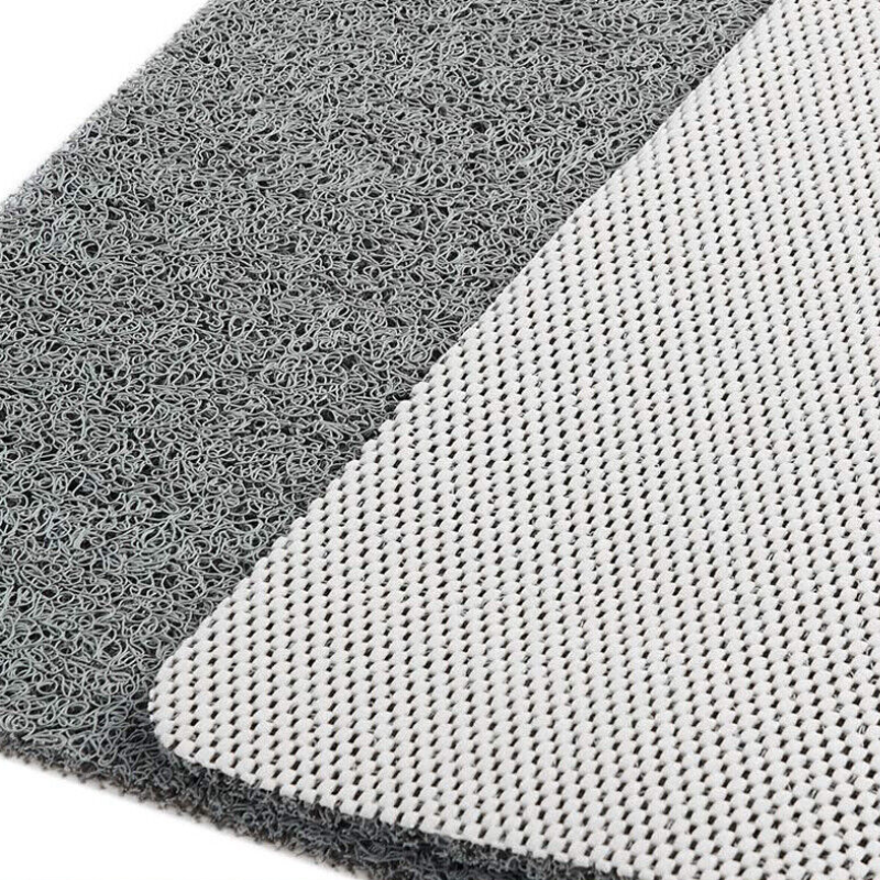 Close-up of a gray textured mat with two sides visible: a coarse looped top surface and a smoother white mesh backing.