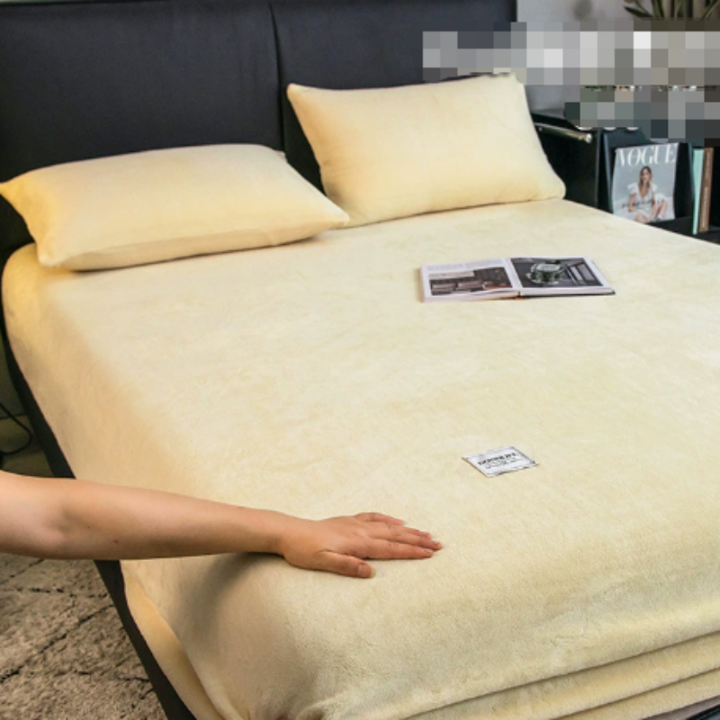 Beige bedspread on a bed with a hand for scale, in a room setting.