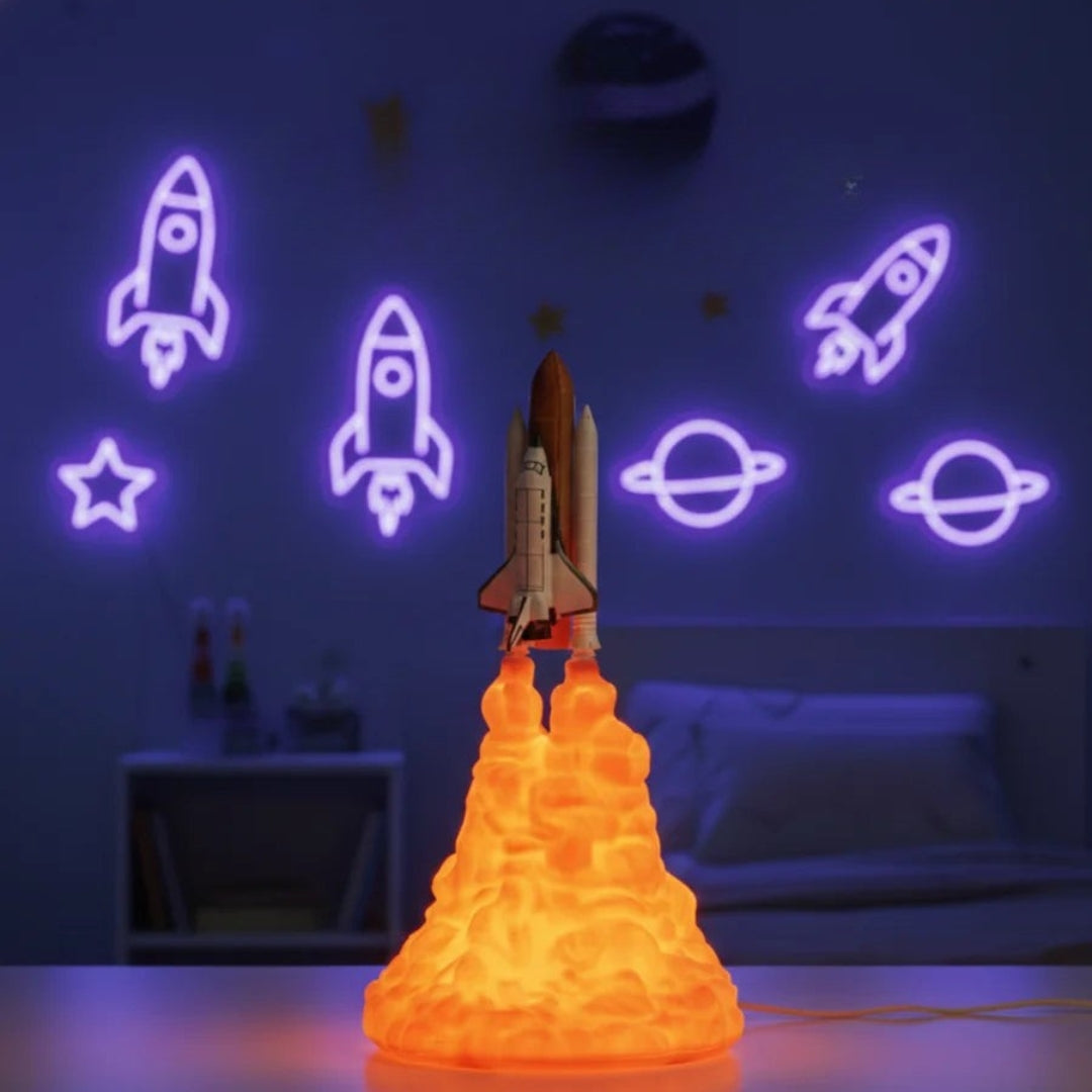Neon light shaped like a rocket ship with glowing outlines of rockets and planets on a wall.
