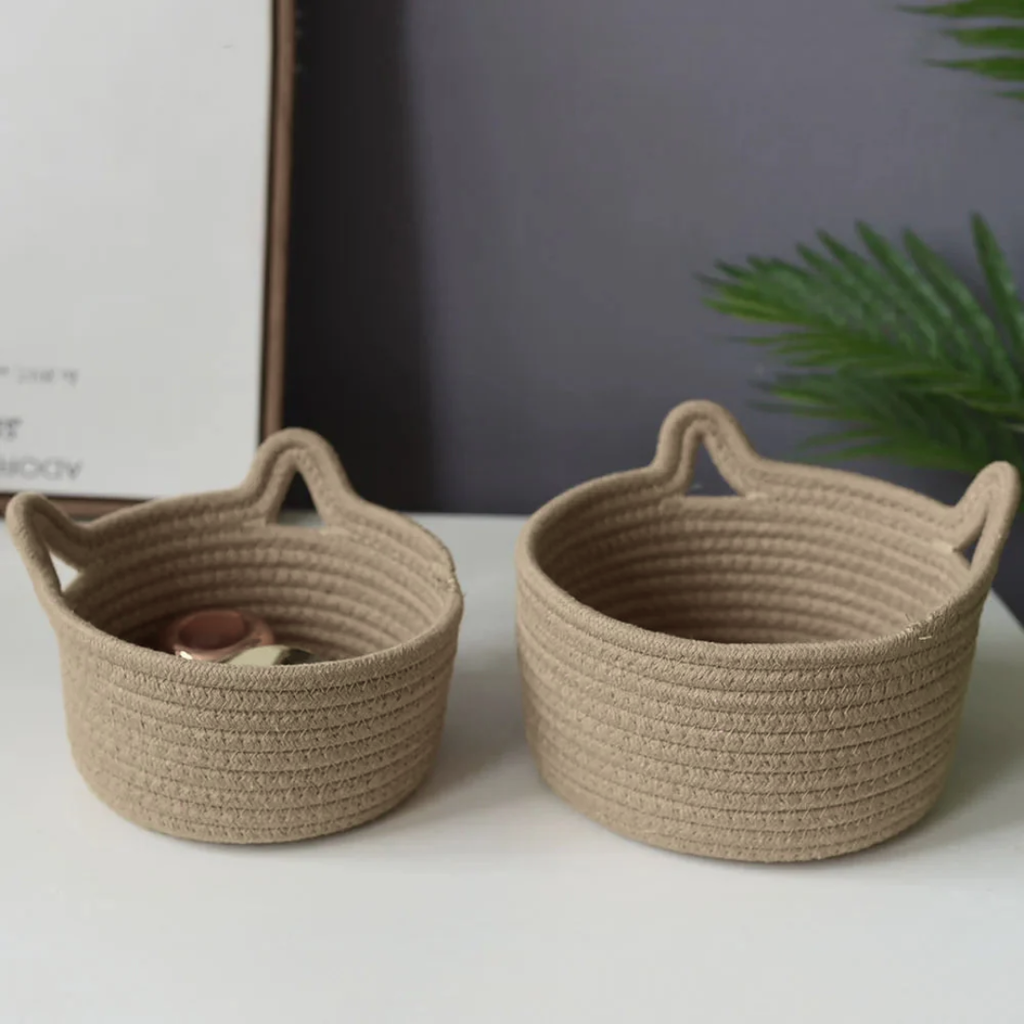 Two woven baskets on a white surface with a blurred background