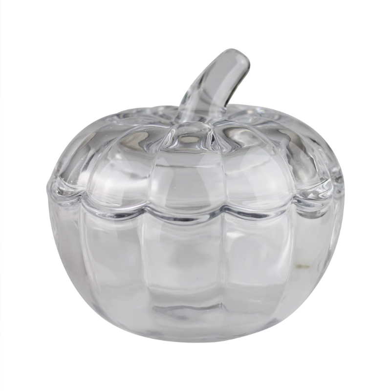 A clear glass pumpkin-shaped container with a ribbed textured body and a matching glass lid, shown on a solid white background.
