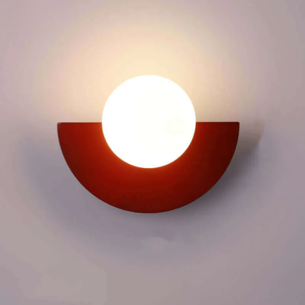 Wall-mounted light fixture with a red semi-circular base on a plain background