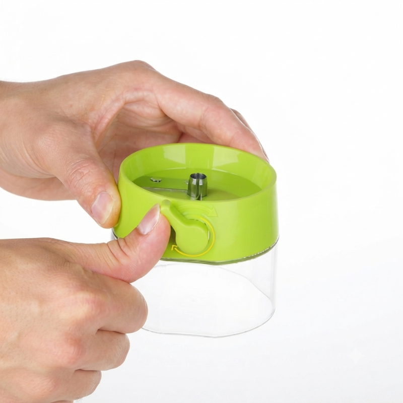 A close-up of a person's hands demonstrating how to insert or remove the lid of a kitchen food chopper with a bright lime green top and a clear container base, set against a plain white background.