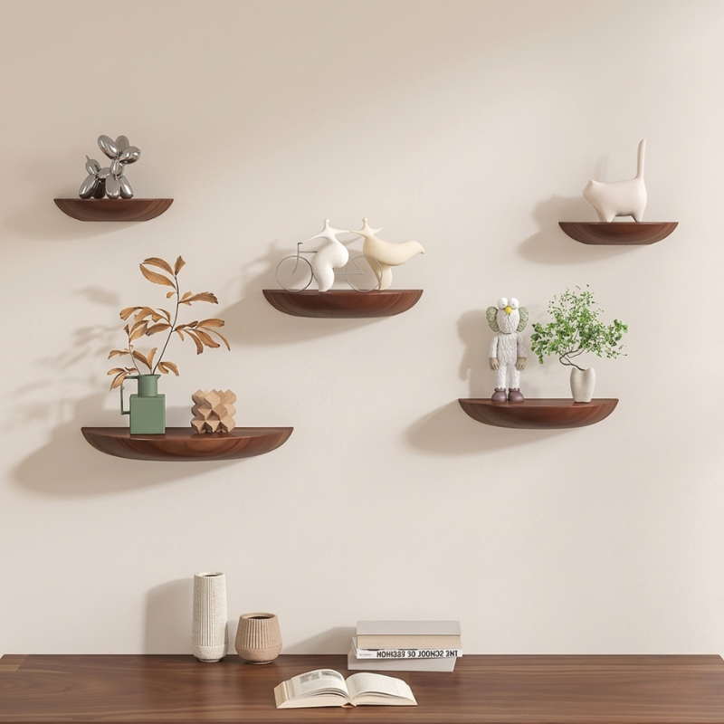 Set of wooden wall shelves with decorative items against a beige wall.