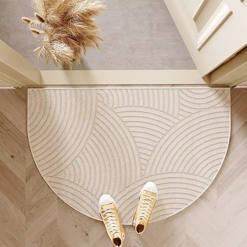 Round doormat with wavy pattern on wooden floor, shoes at entrance