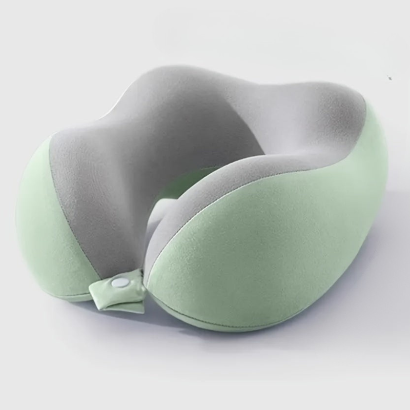 A U-shaped travel neck pillow with a dual-tone design featuring a light sage green exterior and a gray interior, shown on a clean white background.
