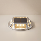 Solar-powered outdoor light fixture on a beige background