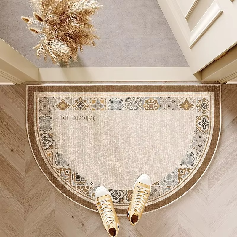 Decorative doormat with ornate border and 'Delicate Life' text, placed on a wooden floor.