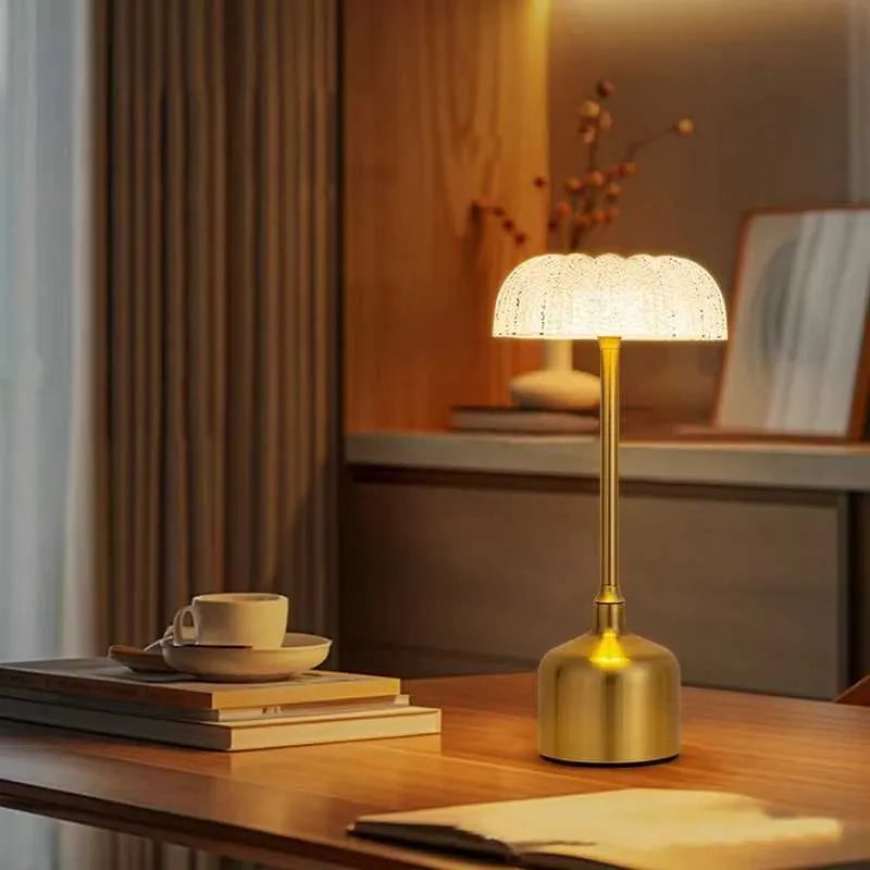 Gold table lamp on a wooden surface with a cozy indoor setting