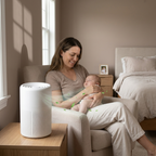 Woman holding a baby next to an air purifier in a bedroom