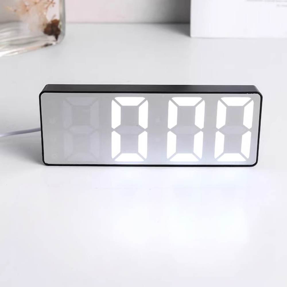 Digital clock with LED display on a white surface