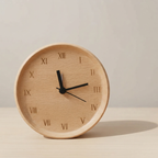 Wooden clock with black hands on a beige background