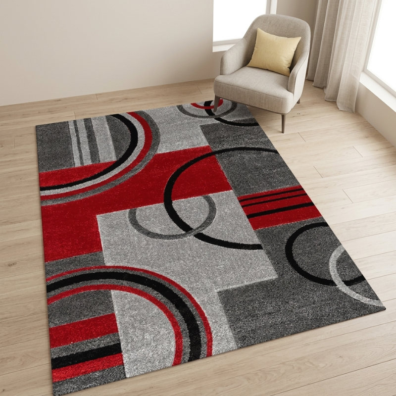 Modern area rug with red, gray, and black circular patterns on a wooden floor.
