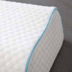 Close-up of a white mattress with a blue border on a gray background