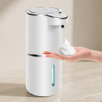 White soap dispenser dispensing soap onto a hand against a beige background