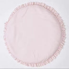 A round light pink fabric cushion with a ruffled edge, photographed flat against a plain white background.