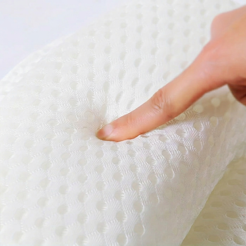 Hand touching a textured white mattress surface