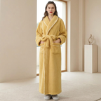 Woman wearing a yellow robe in a minimalistic room.