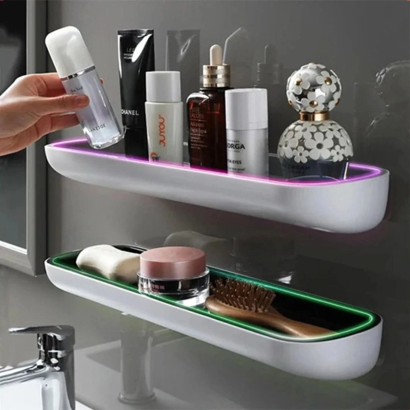 Bathroom shelf with various products including a bottle, tube, and brush on a gray wall background.