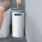 White trash bin with blue interior next to a toilet in a bathroom setting