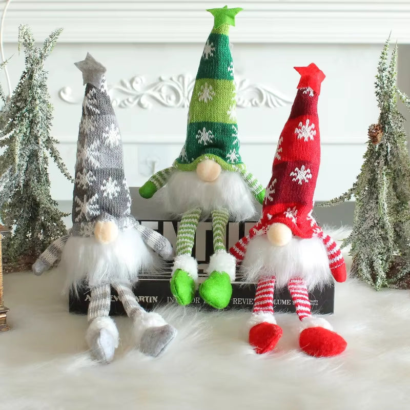 Three Christmas-themed gnomes with colorful hats and outfits on a white surface.