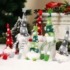 Decorative Christmas gnomes with colorful hats and striped pants in a festive setting.