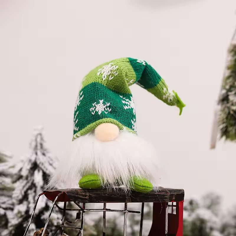 Green knitted hat with white patterns on a blurred snowy background