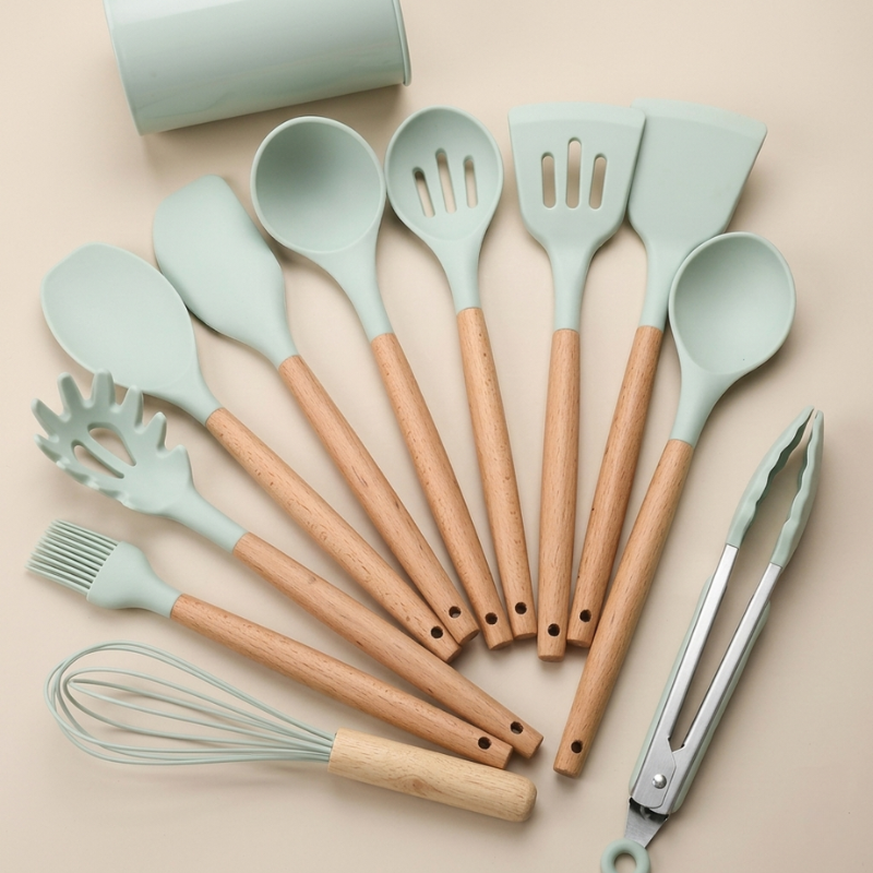 Set of kitchen utensils with wooden handles and green silicone heads on a beige background