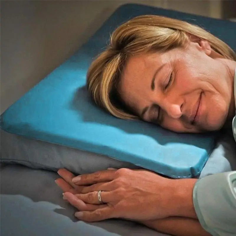 Woman lying on a blue wedge pillow in a bedroom setting