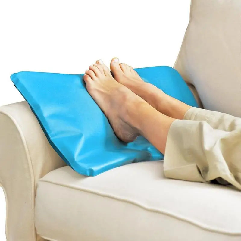 Person using a blue footrest on a beige couch